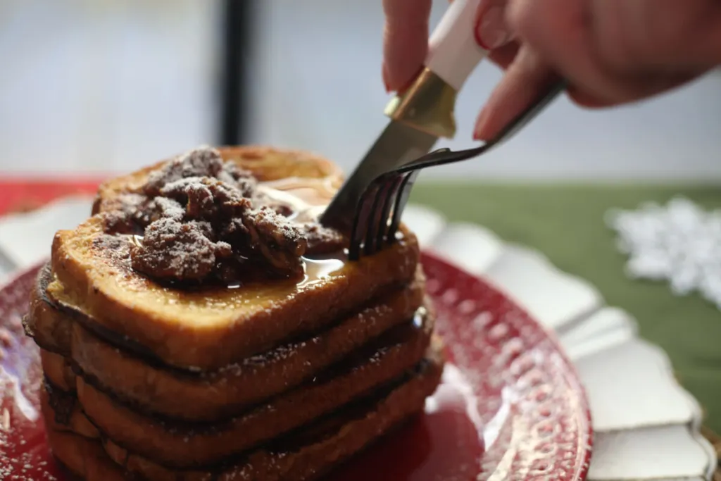 A knife and fork cutting through stacked Eggnog Cinnamon French Toast