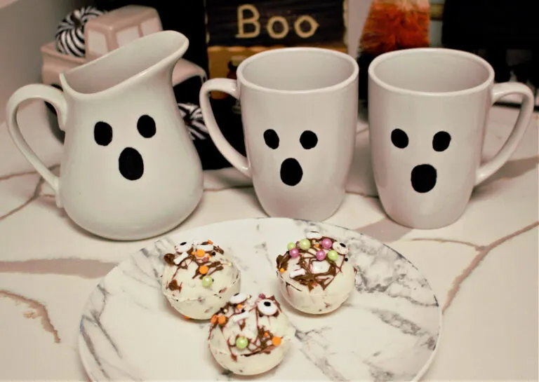 Three ghost pitchers behind three Halloween Hot Cocoa Bombs