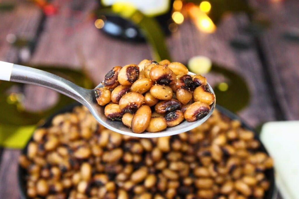 A spoonful of Air Fryer Black Eyed Peas in front of a bowl.