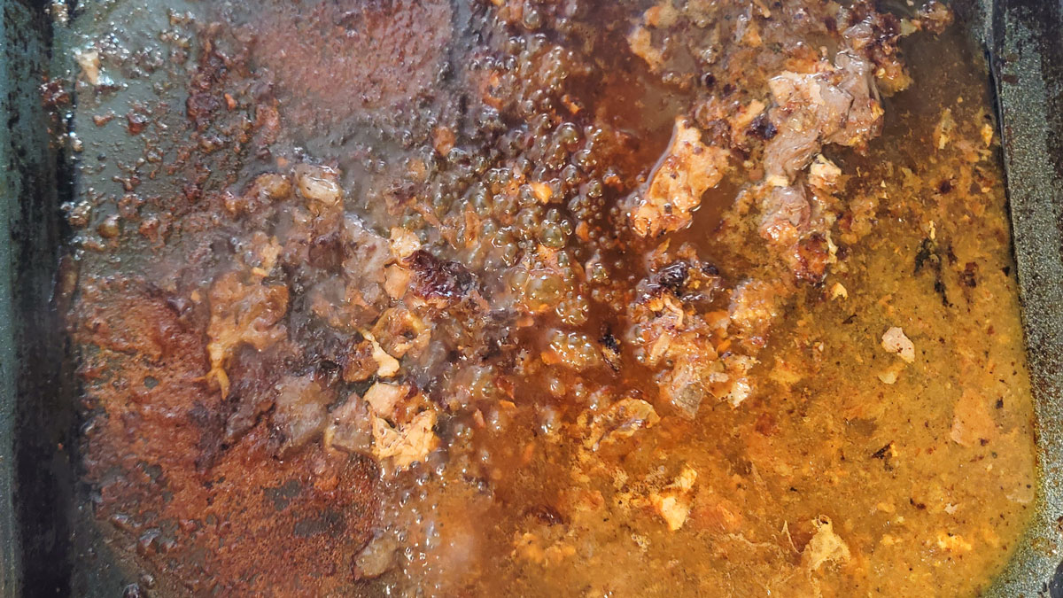 Browned drippings in the roasting pan.
