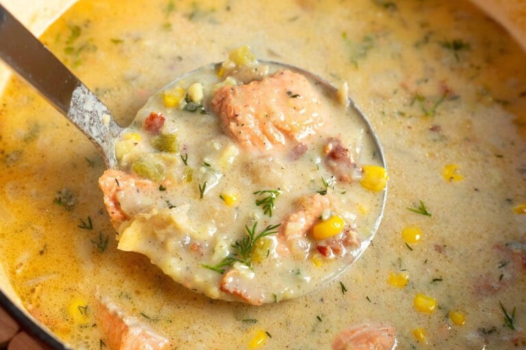 A ladle full of Salmon Chowder from a bowl.