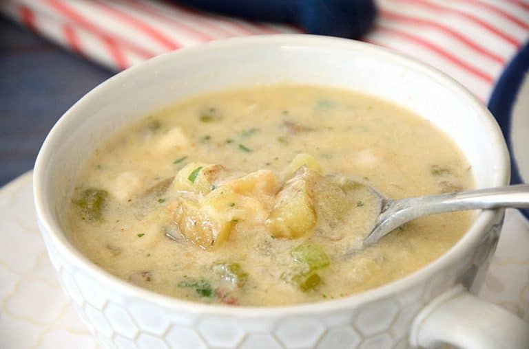 A bowl of Smoky Scallop Chowder with a spoon inside