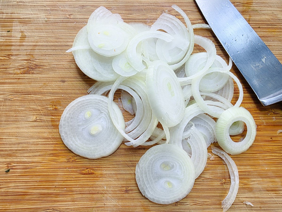Sliced onions on a cutting board.