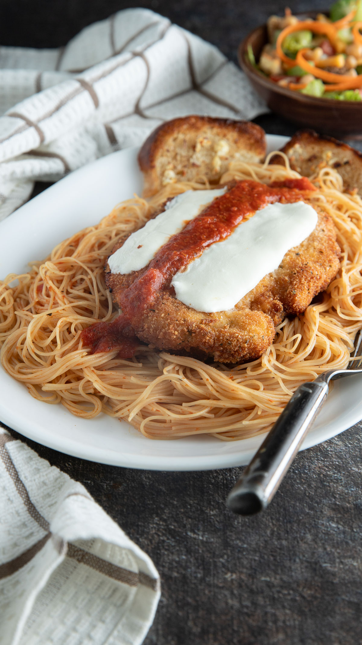 Large platter with pasta and chicken parmesan.
