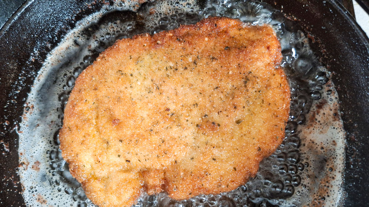 Browning chicken breast in a cast iron skillet.