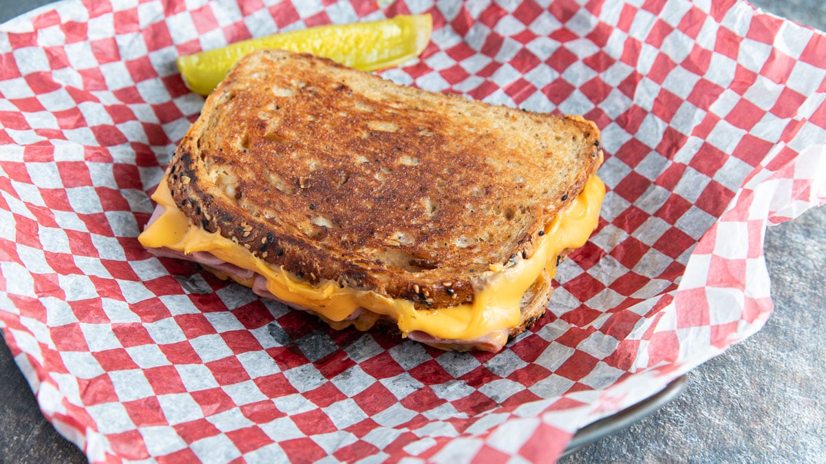 Grilled ham and cheese with pickle spear.