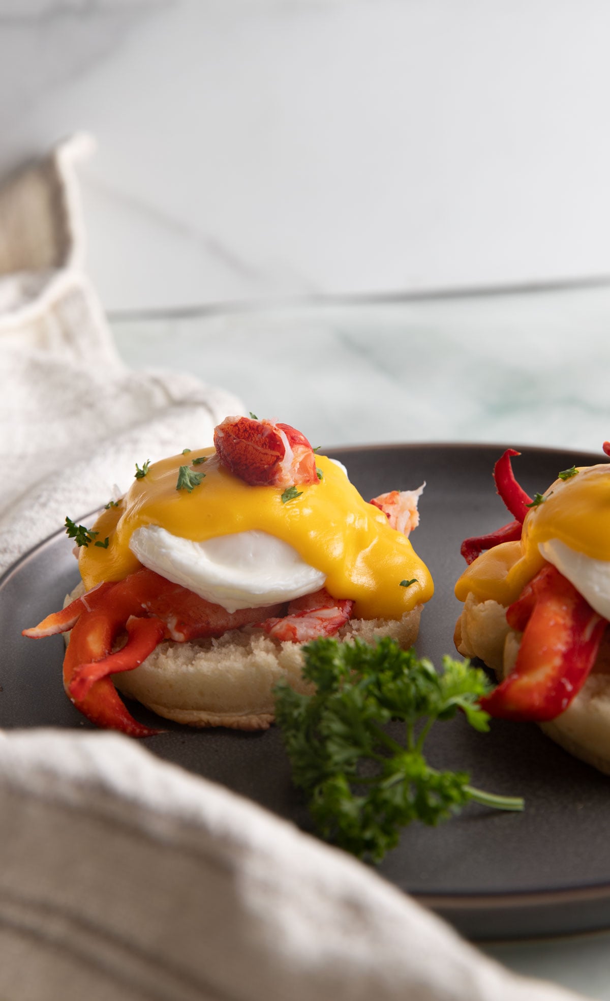 Lobster benedict on a gray plate.