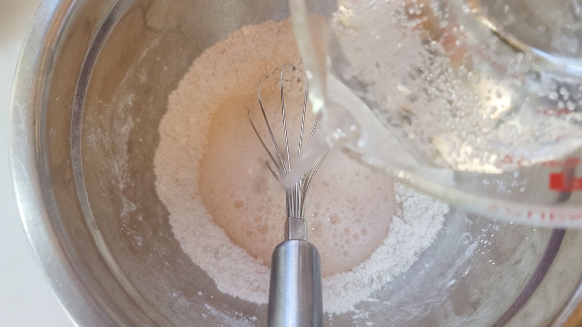 Pouring water into batter.