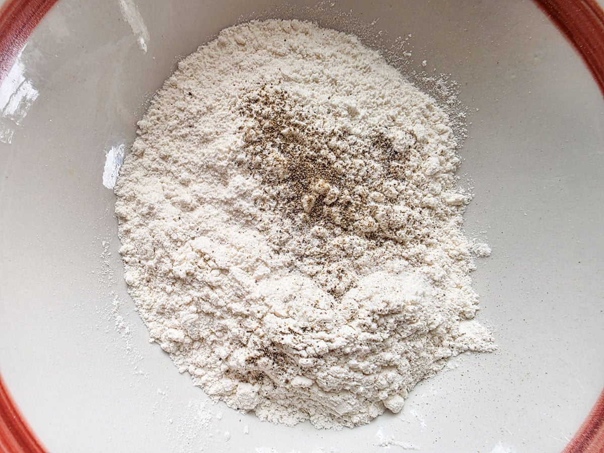 Seasoned flour in a white bowl.