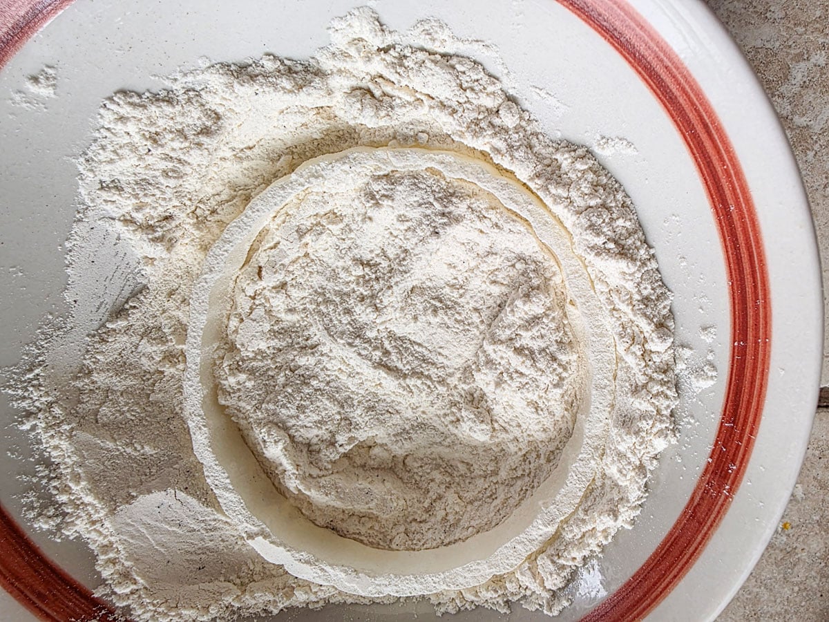 Dredging onion in seasoned flour.