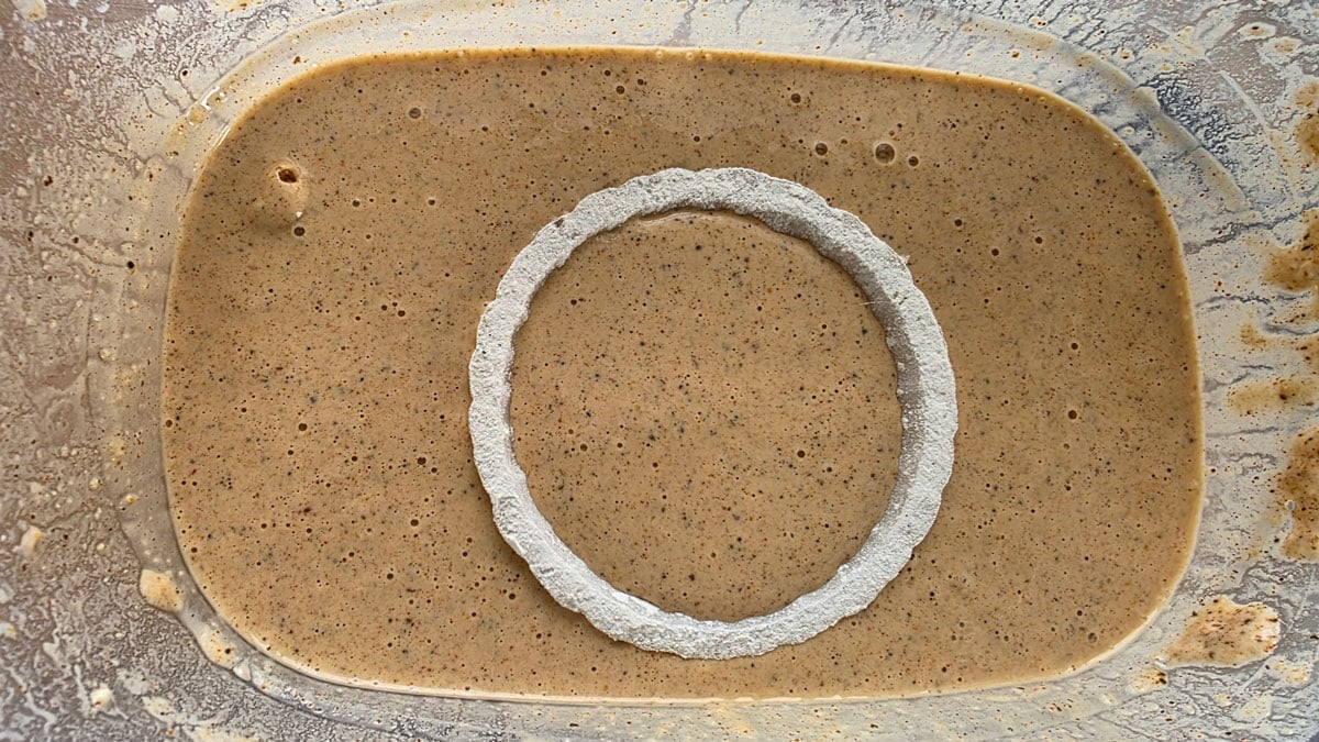 Dipping onion rind in a bowl with batter.