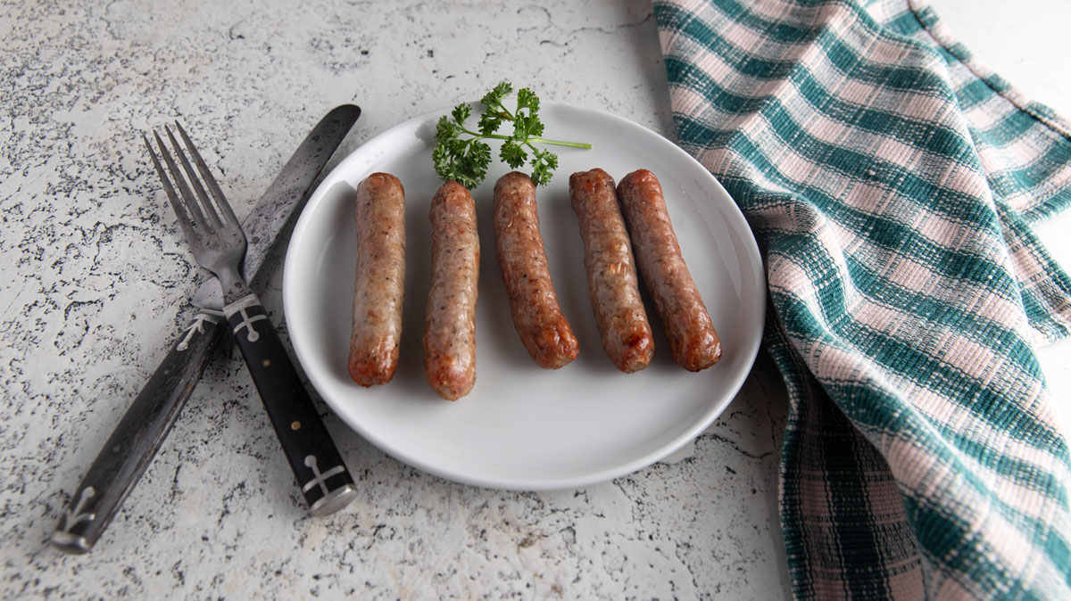 Air fried sausage on a white plate.