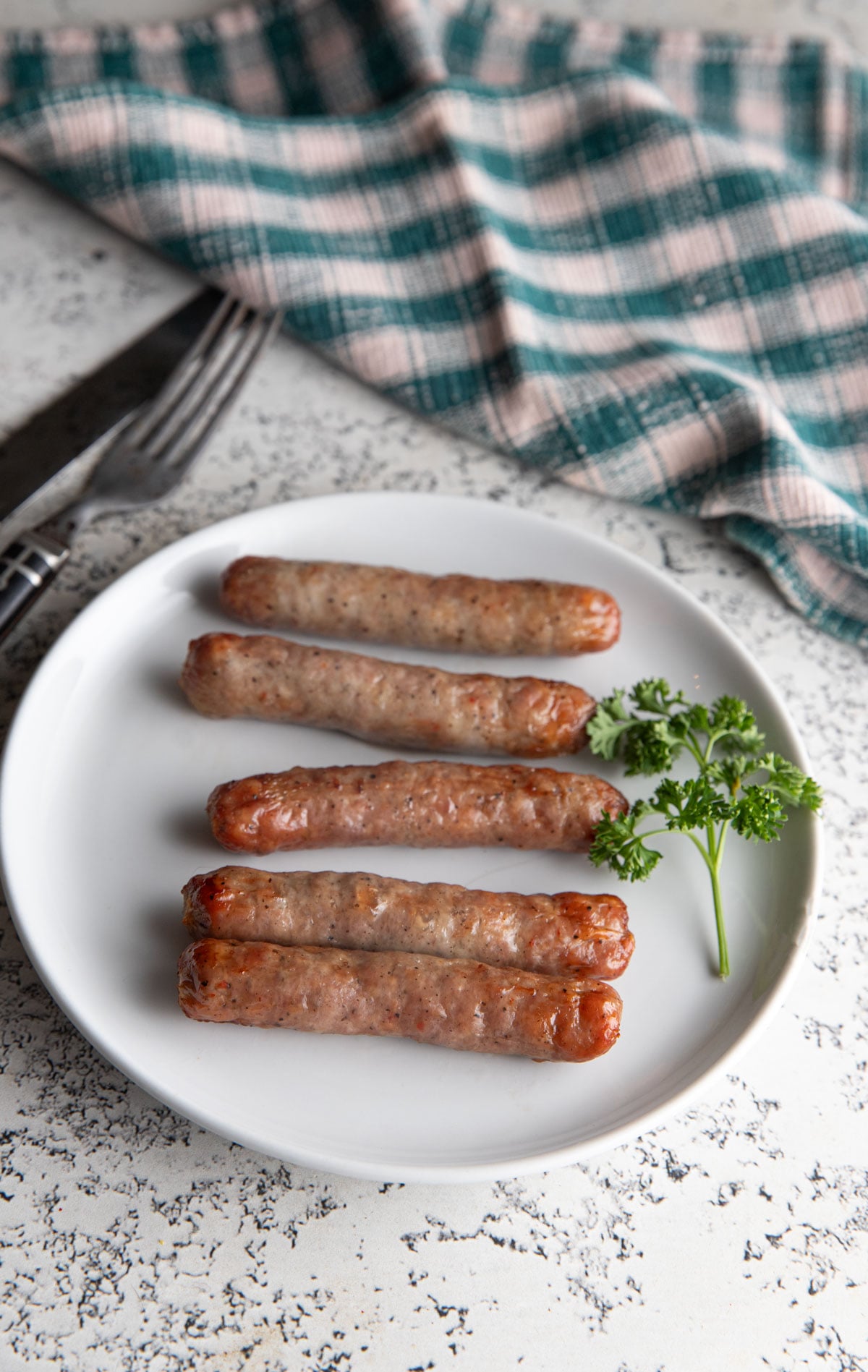 Air fried breakfast sausage on a white plate.
