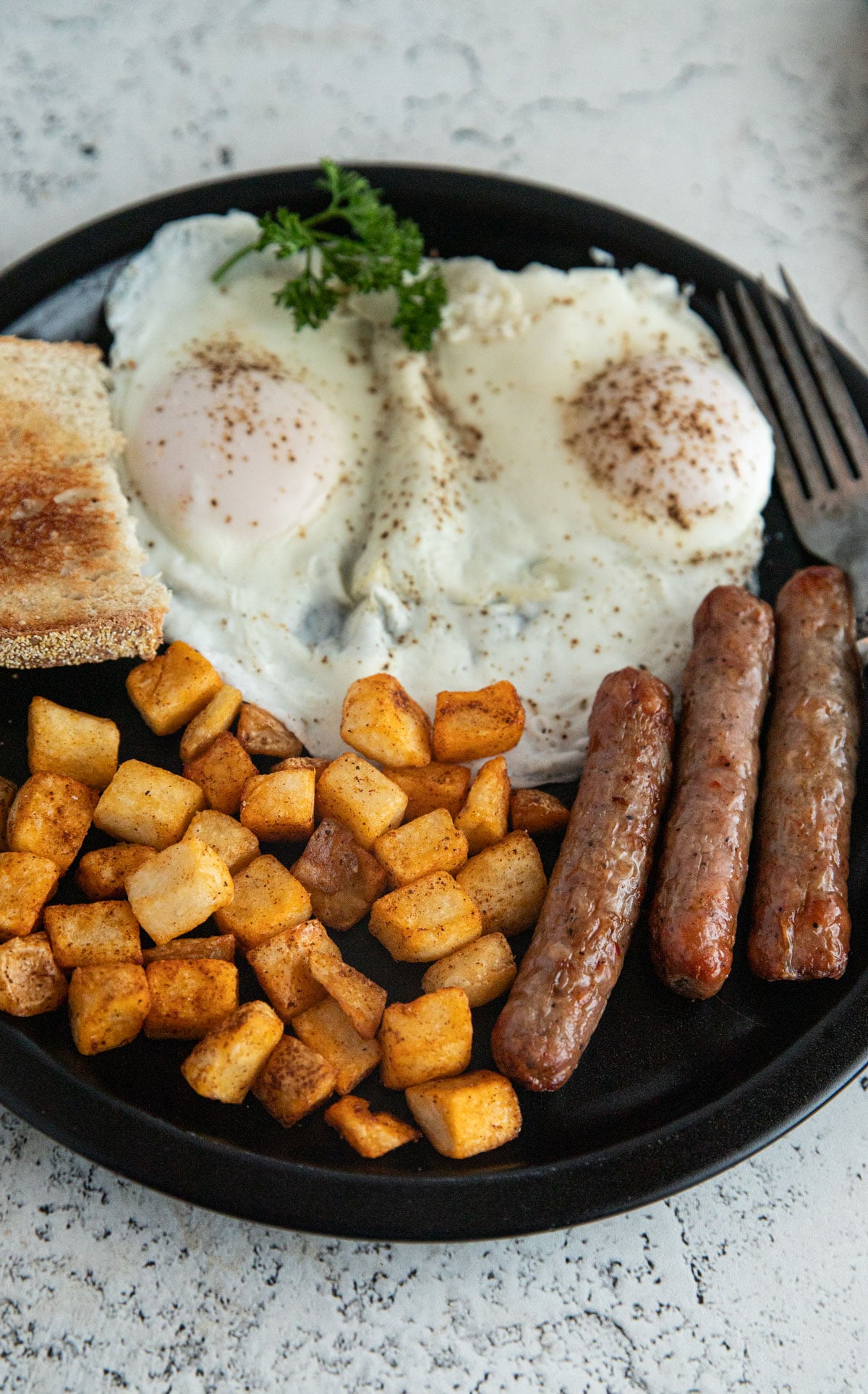 Air fried breakfast with sausage, hash browns and eggs.