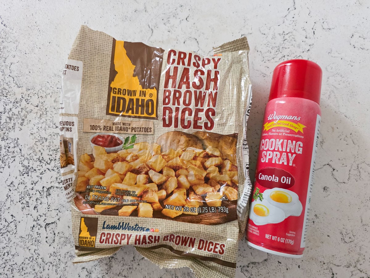 Bag of hash browns and cooking spray on a white board.