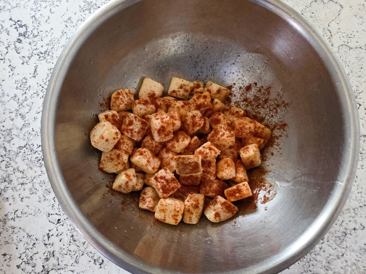 Hash browns in a bowl with spices.