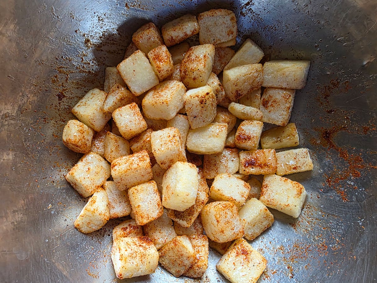 Mixed hasg browns with spices in the bowl.