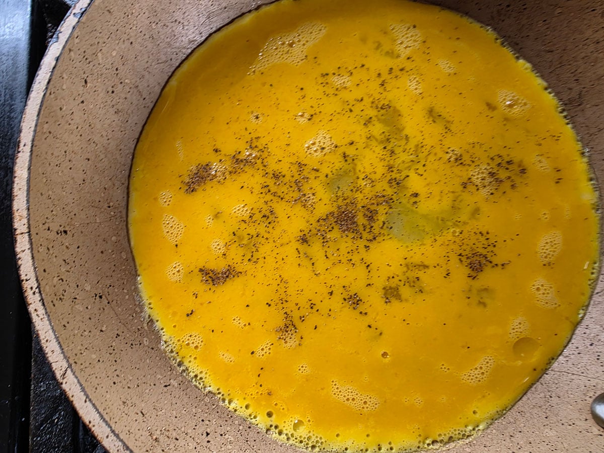 Whisked eggs in a skillet.