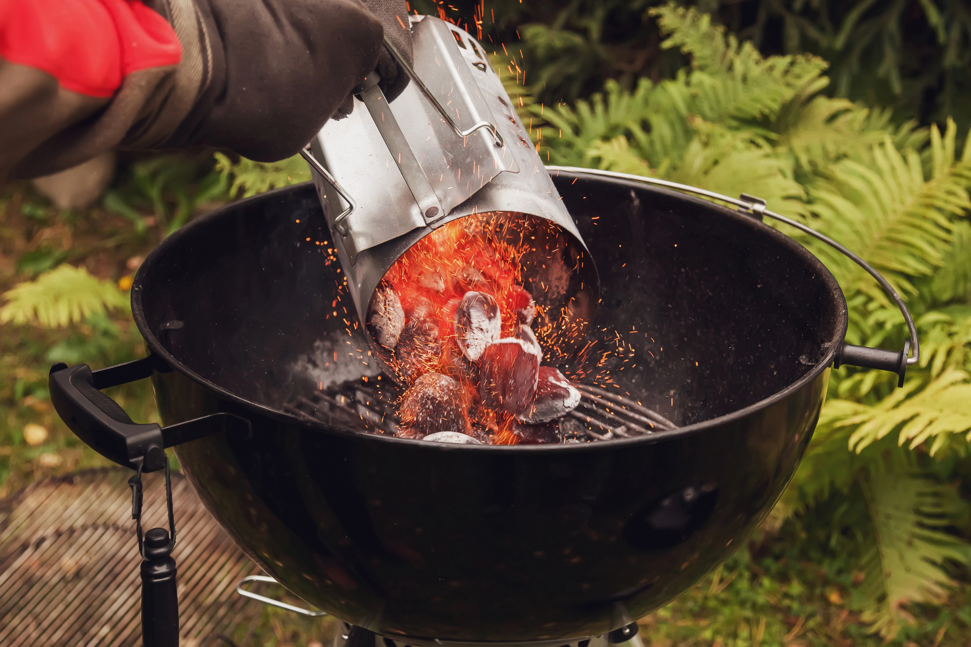 Pouring charcoal briquets from a chiney starter.
