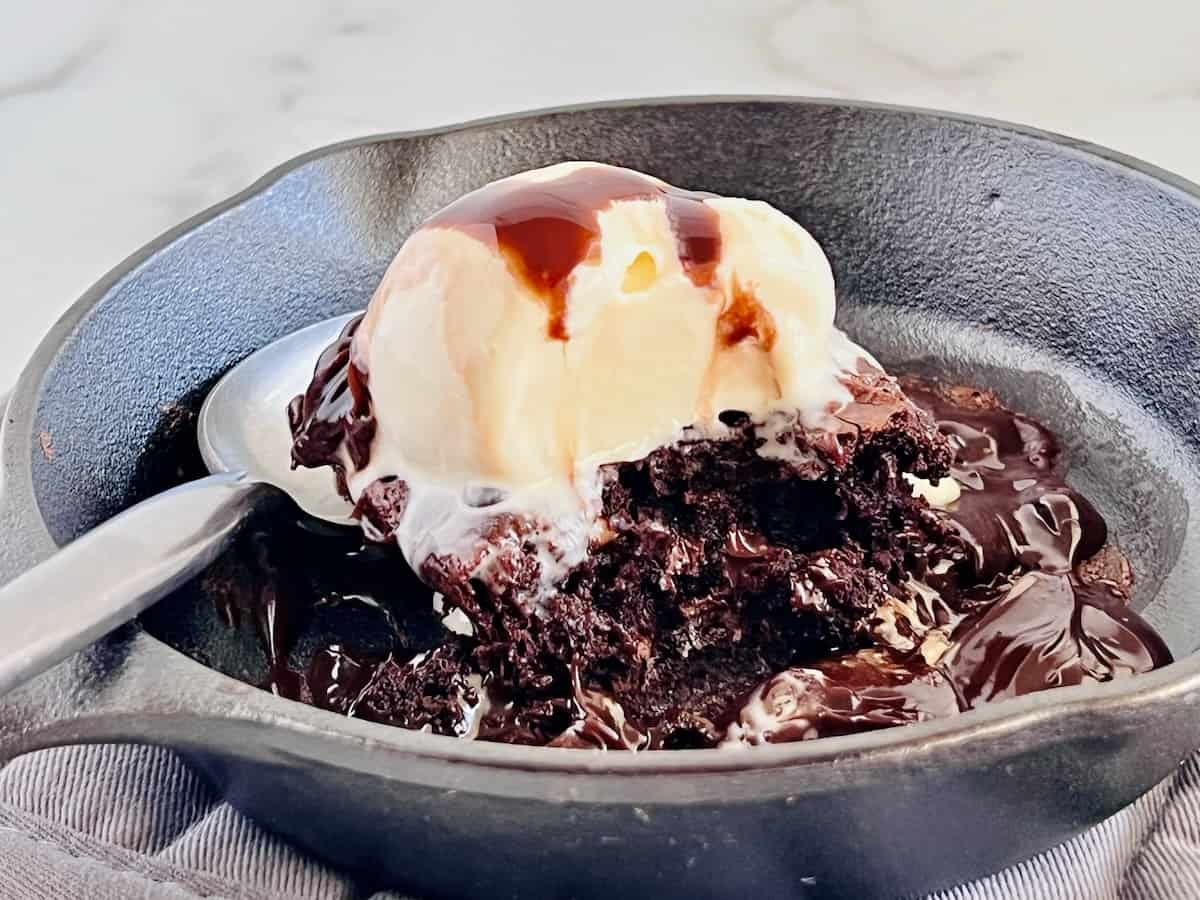 Sizzling Brownies on a skillet with ice cream on top.