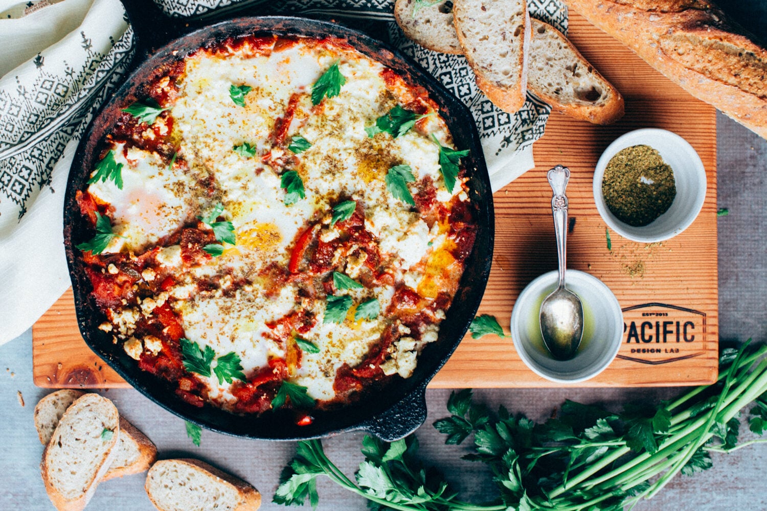 A skillet of Shakshuka (Baked eggs in Tomato Sauce) with Broiled Feta