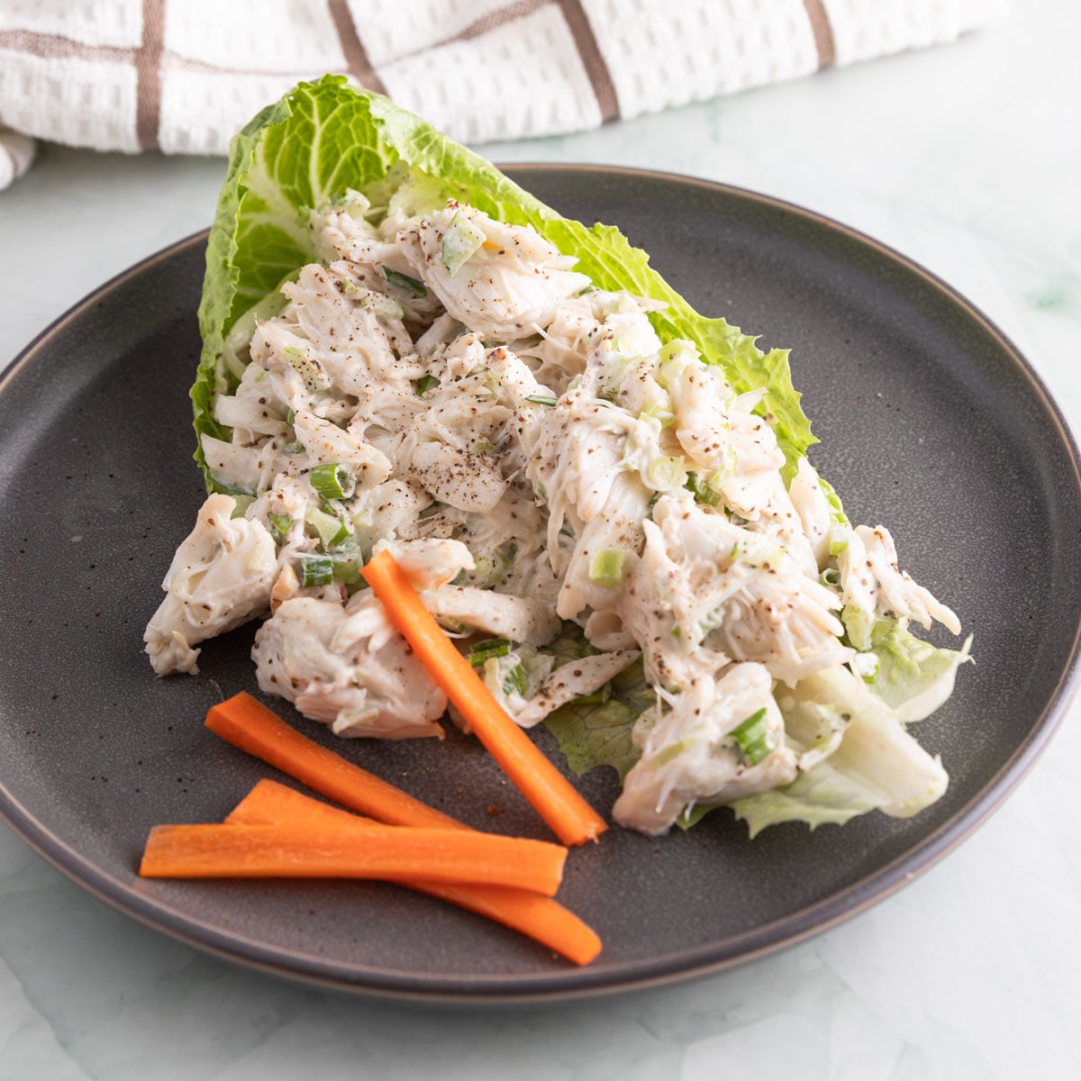 Crab salad in a lettuce leaf with julienned carrots.