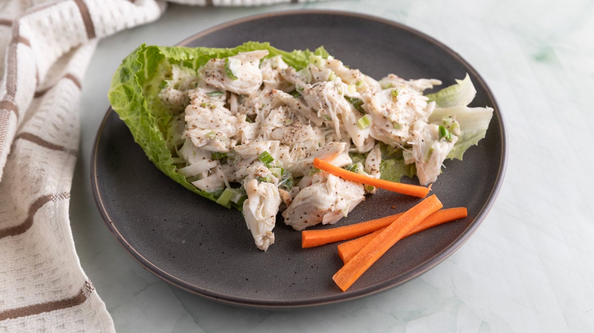 Crba salad in a lettuce leaf on a gray plate.