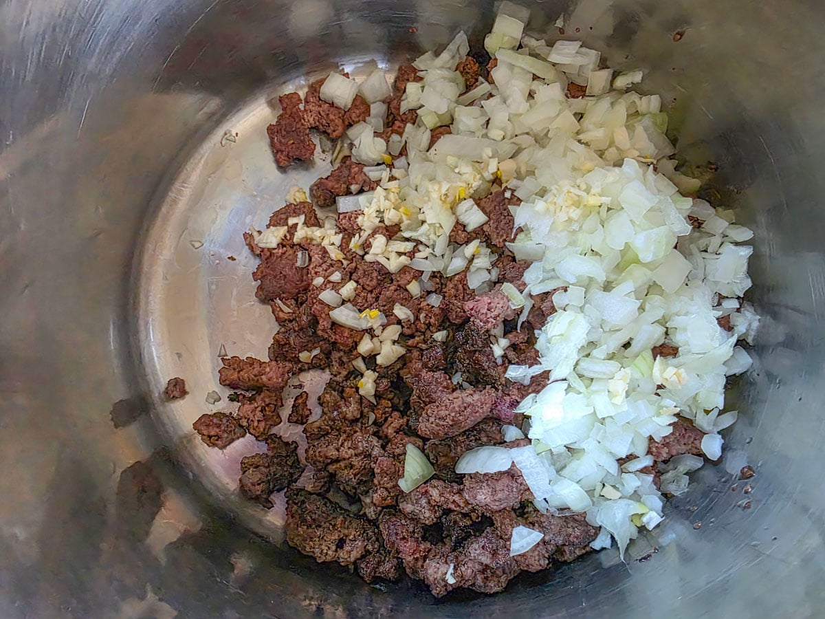 Meat and onions in a Dutch oven.