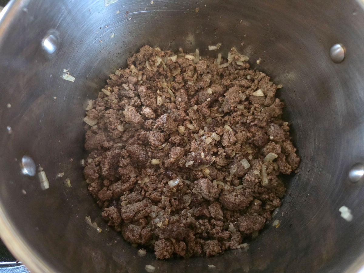 Broned meat and onions in Dutch oven.