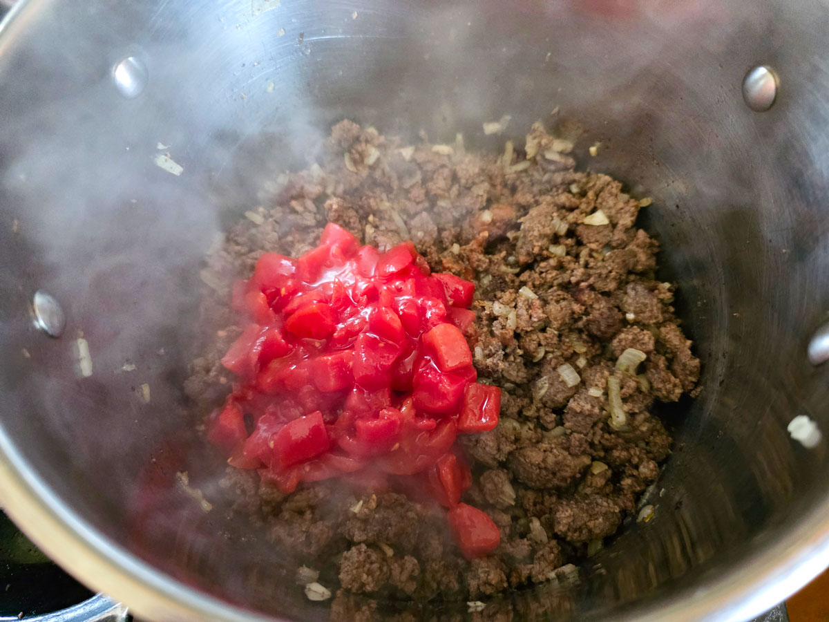 Tomatoes and water added to the pot.