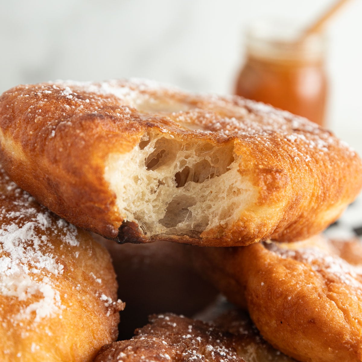 Bite taken out of fried dough to reveal a soft, doughy center.