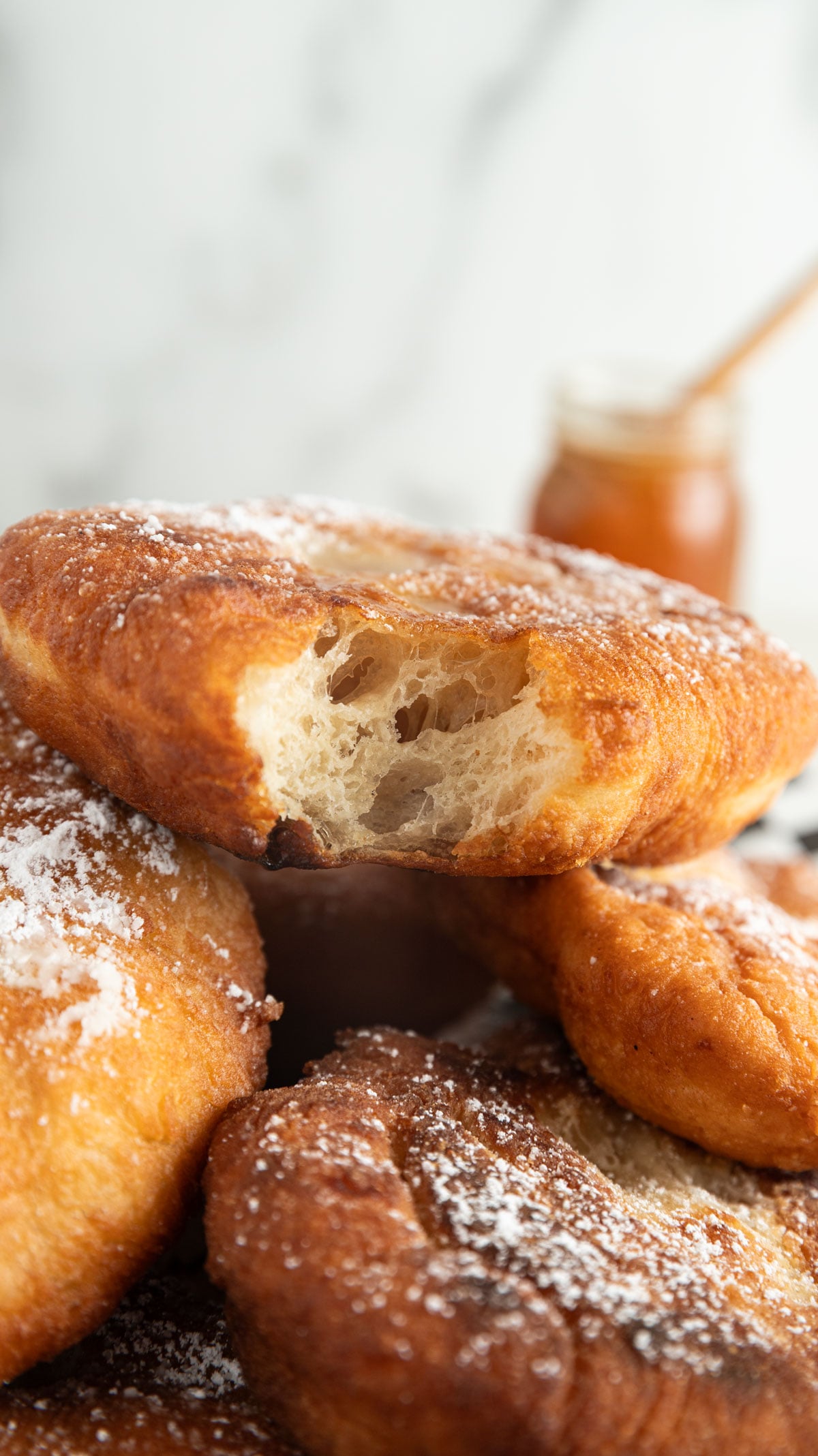 Bite taken out of a powdered sugar cover fried dough.