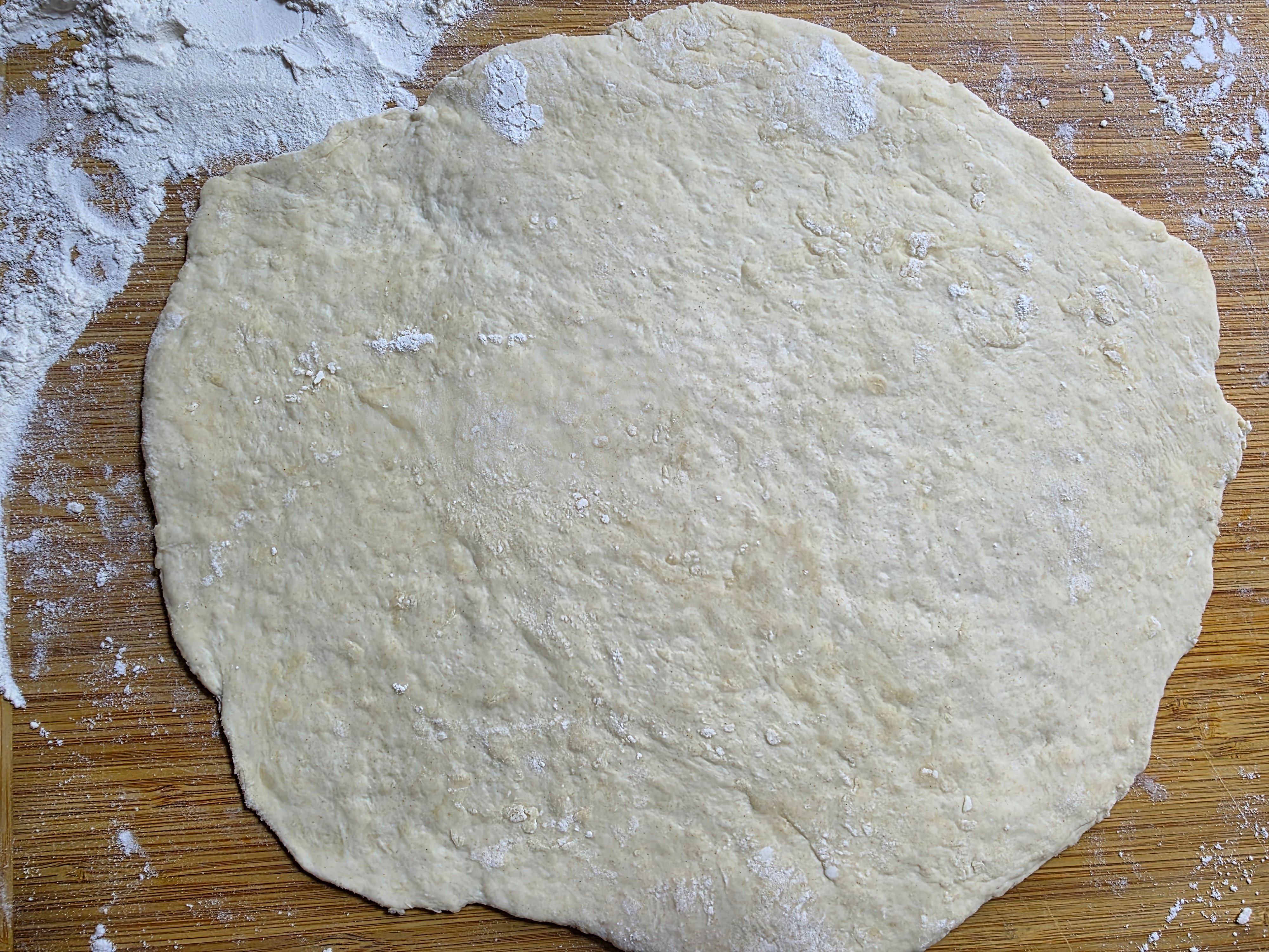 Dough rolled out on a floured cutting board.