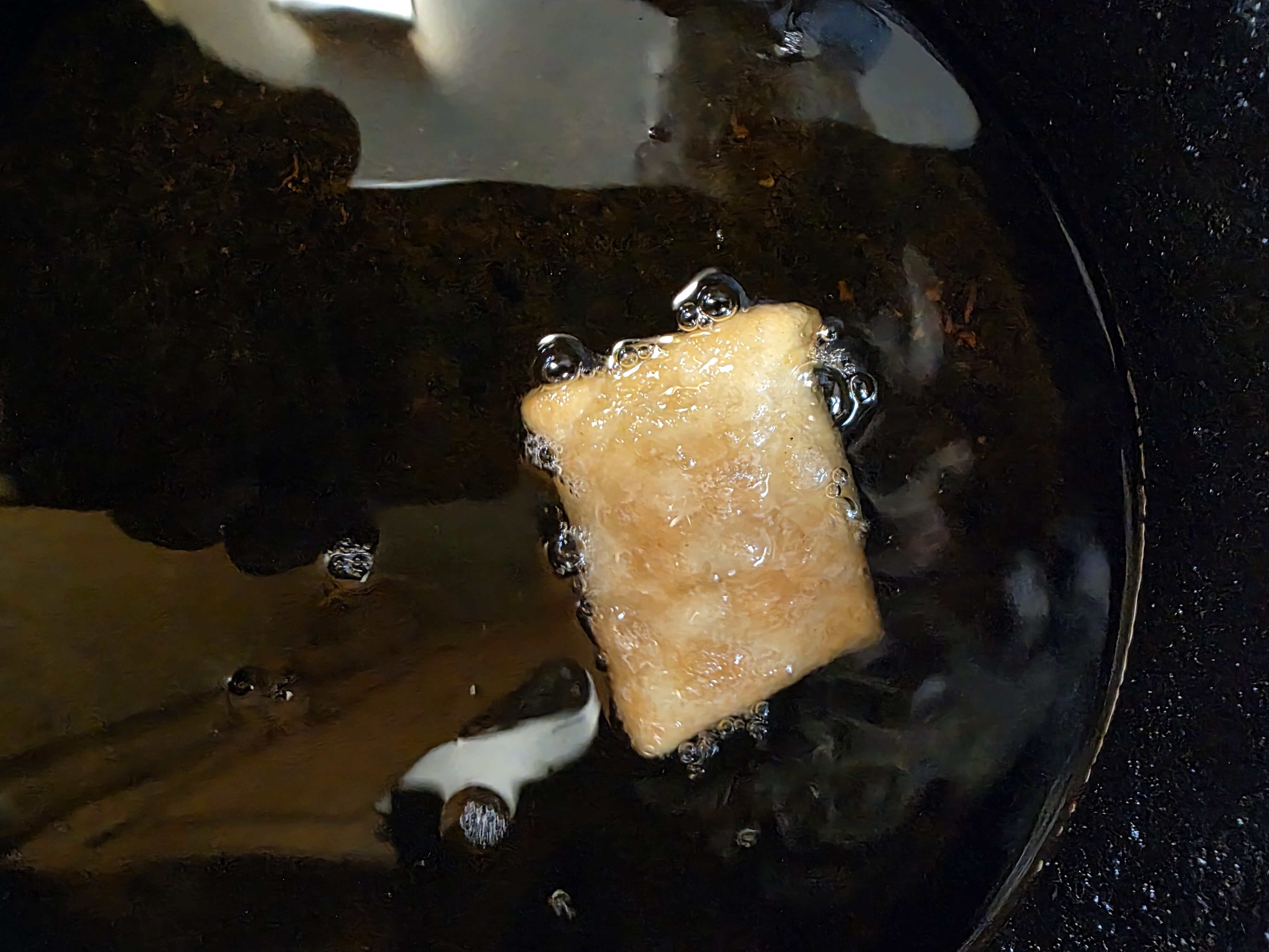 Sopapillas frying in hot oil.