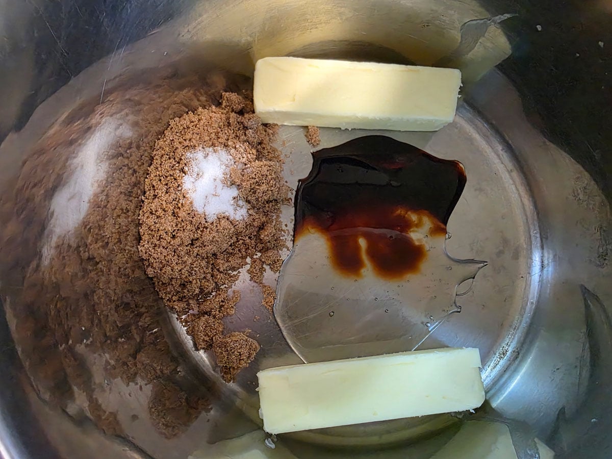 Ingredients for caramel corn added to a large Dutch oven.