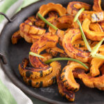 Orange delicata squash roasted with caramelized edges.