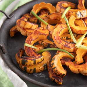 Orange delicata squash roasted with caramelized edges.