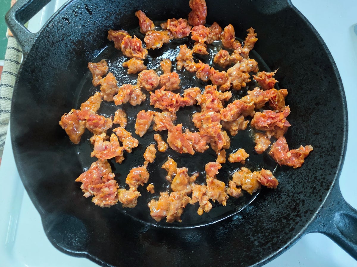 Chorizo browning in a cast iron pan.