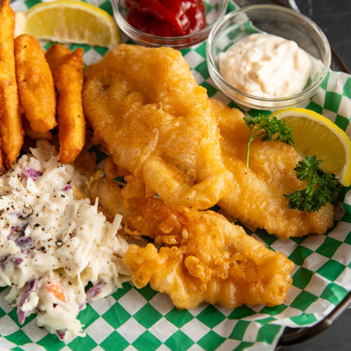 Beer-battered perch fish fry on a platter with fries and coleslaw.