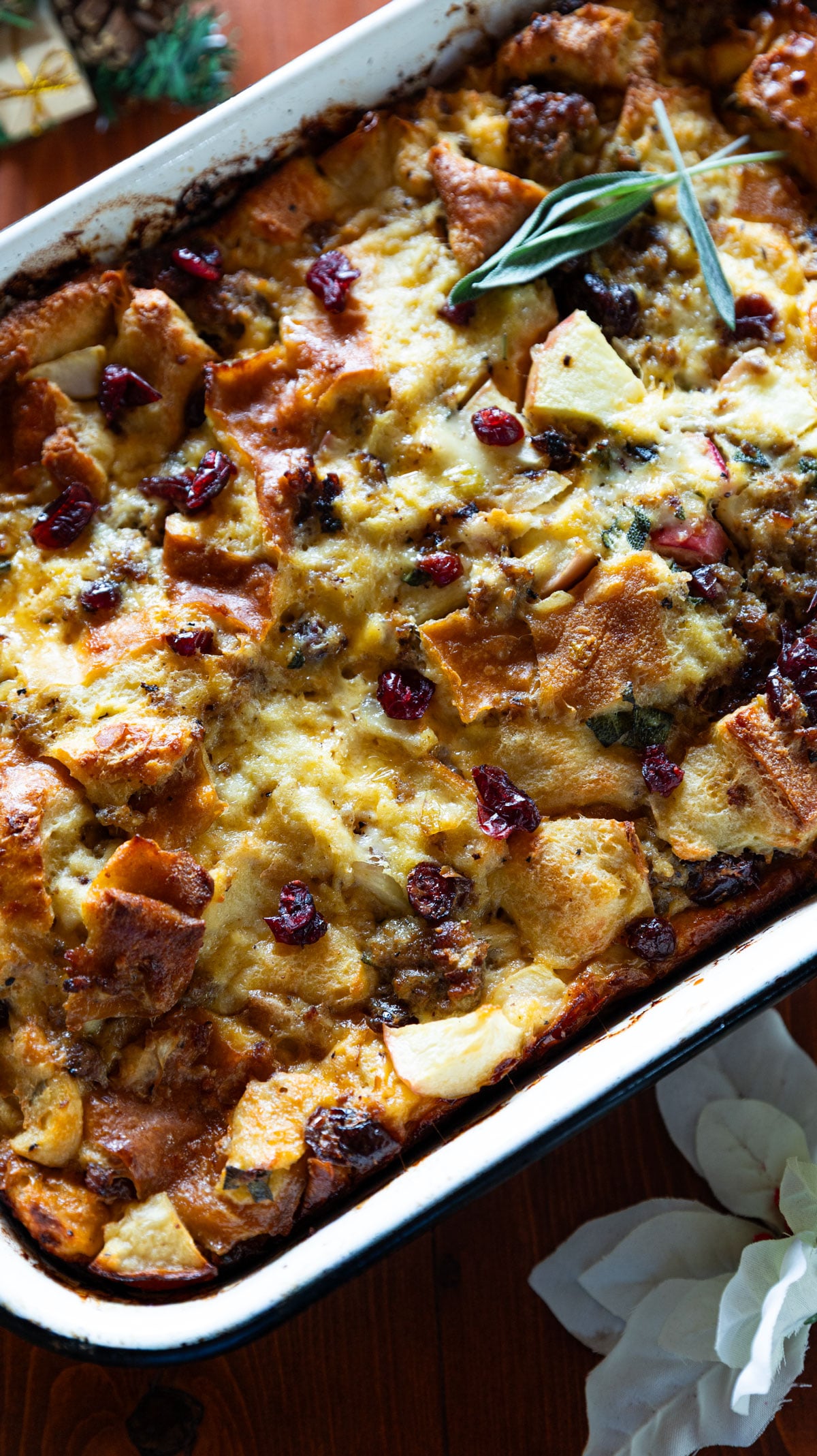 Colorful sausage casserole with herbs, cheese, dried cranberries and apples.