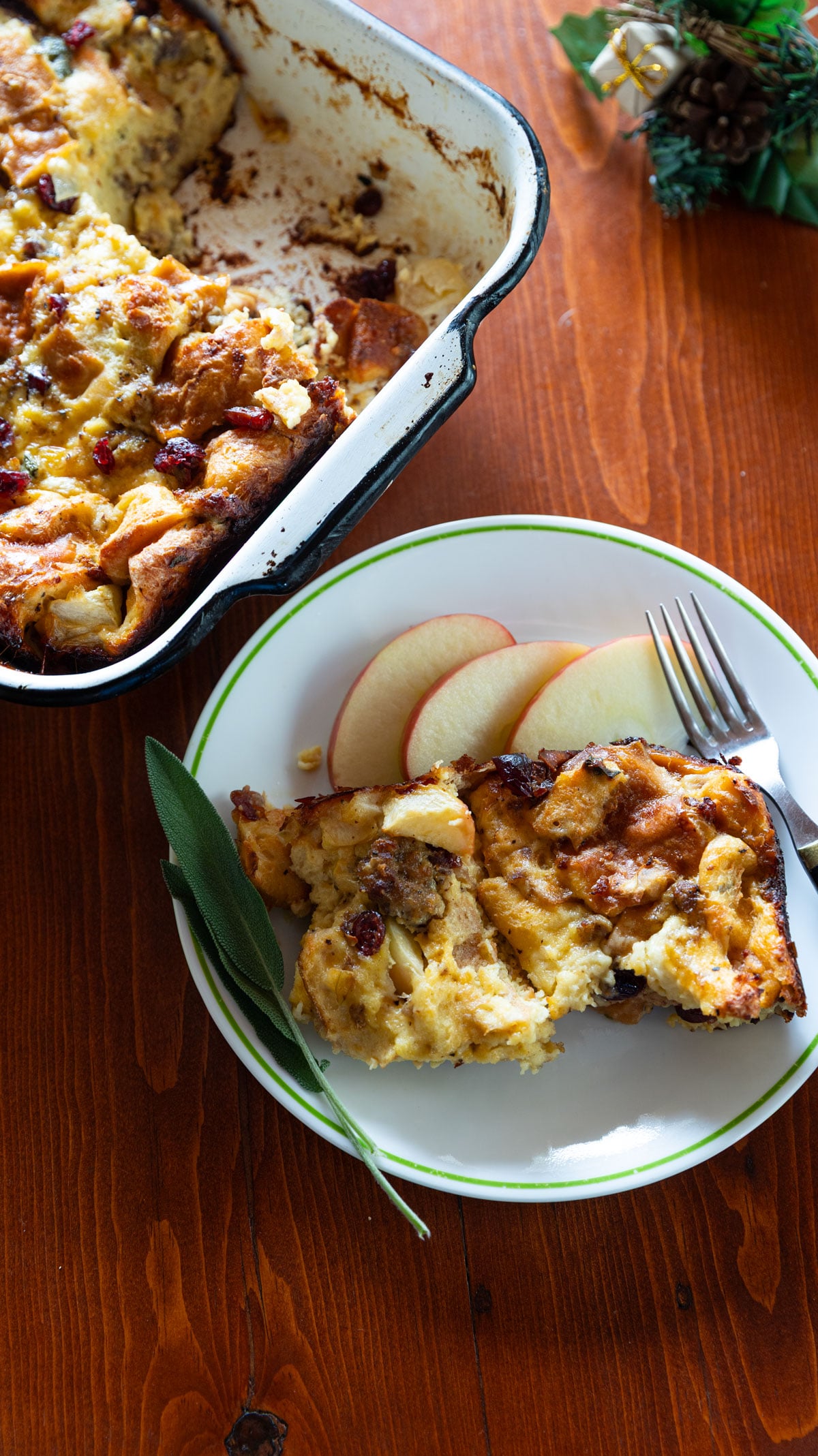 Plate with a piece of sausage breakfast casserole with apple slices.